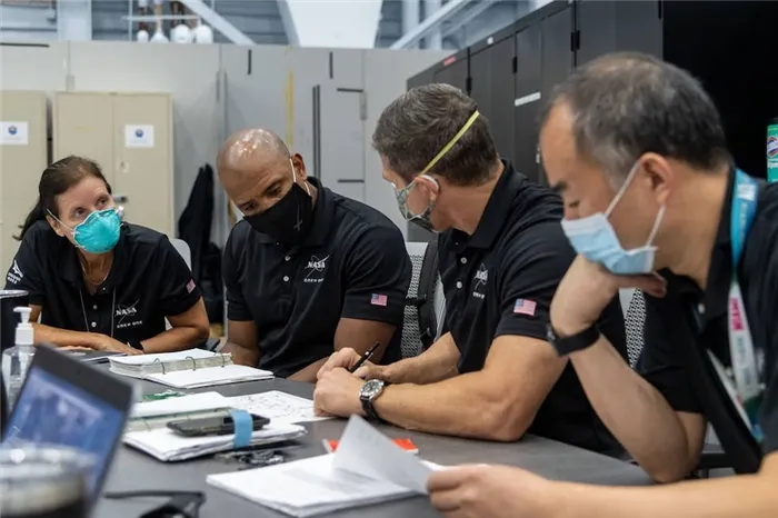 Специалист миссии Шеннон Уокер (слева), пилот Виктор Гловер и член экипажа Dragon Майкл Хопкинс (все - NASA ) на корабле SpaceX Cre 1 миссии ISS на стартовом комплексе NASA 39A. Он встретился со специалистом JAXA Ног Усоичи. Космический центр имени Кеннеди во Флориде в ноябре 2020 года.